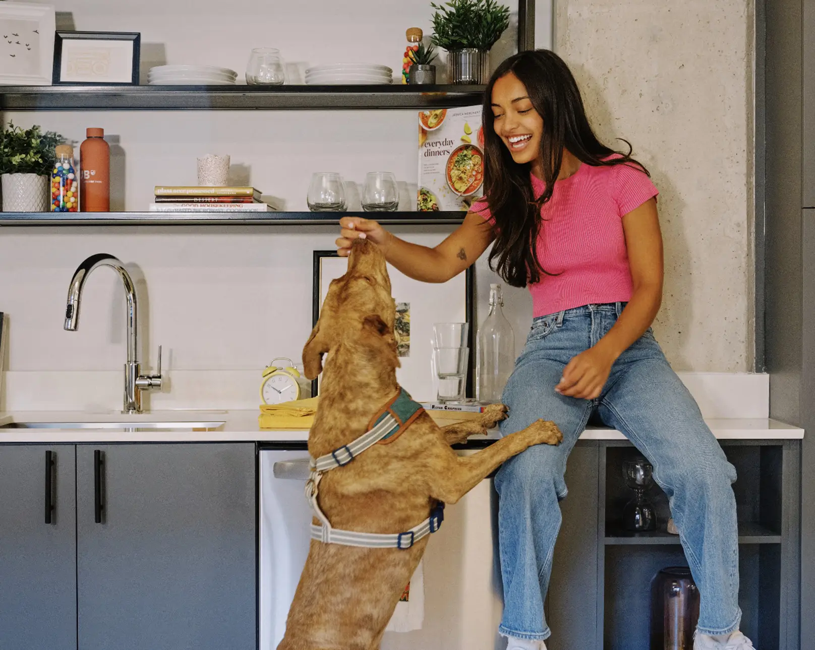Woman sitting in the kitchen with a dog